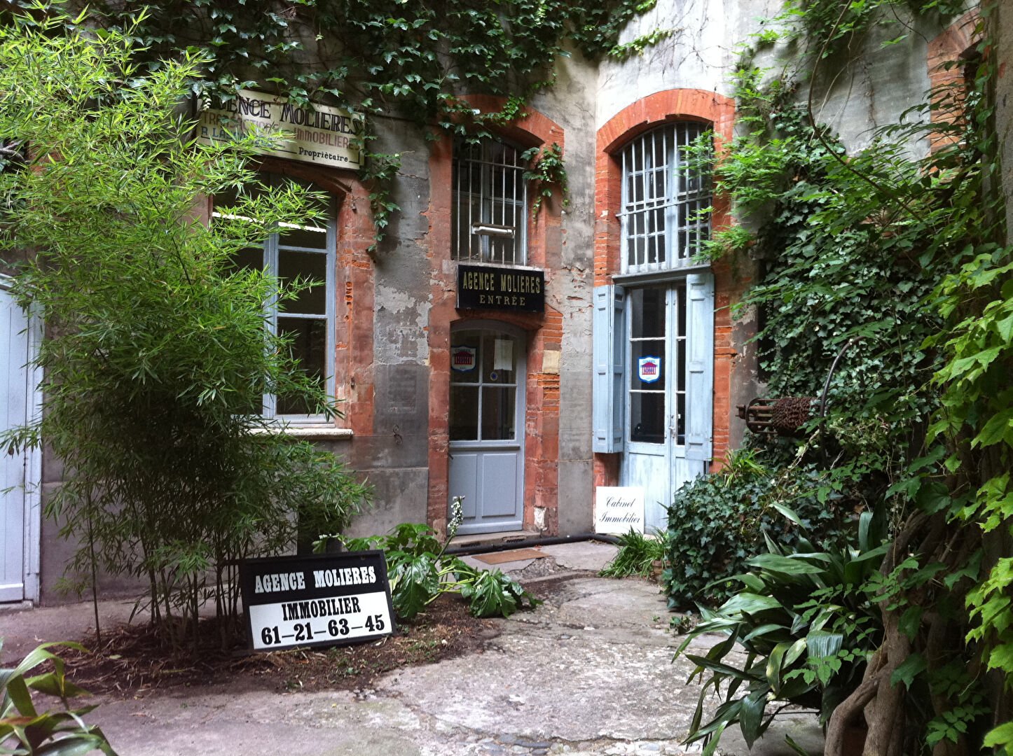 L'entrée de l'agence Molières, dans une cour plantée